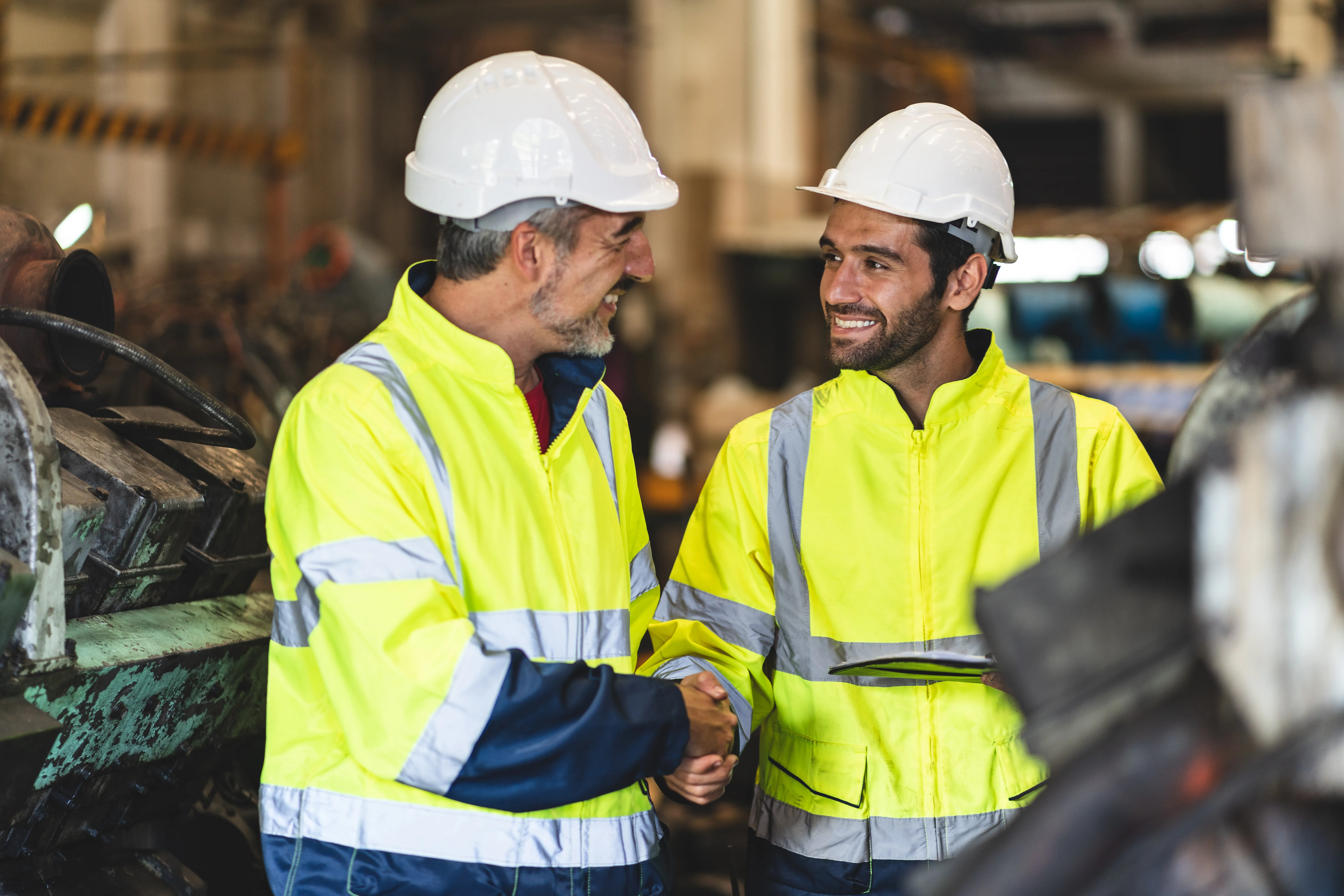 Image of contractors and engineers shaking hands and smiling as they come to an agreement.